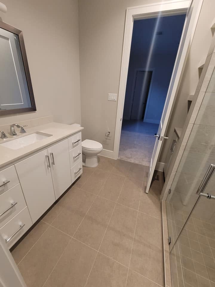 Modern bathroom with white vanity, toilet, and tile flooring