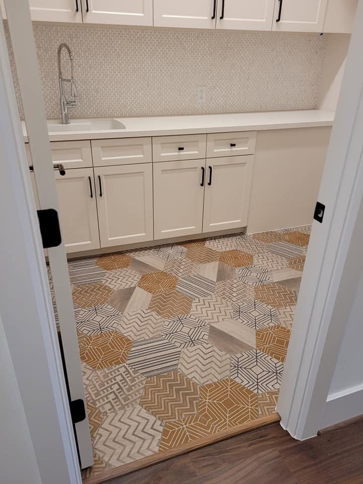 Modern kitchen with white cabinetry, geometric tile backsplash, and patterned floor tiles
